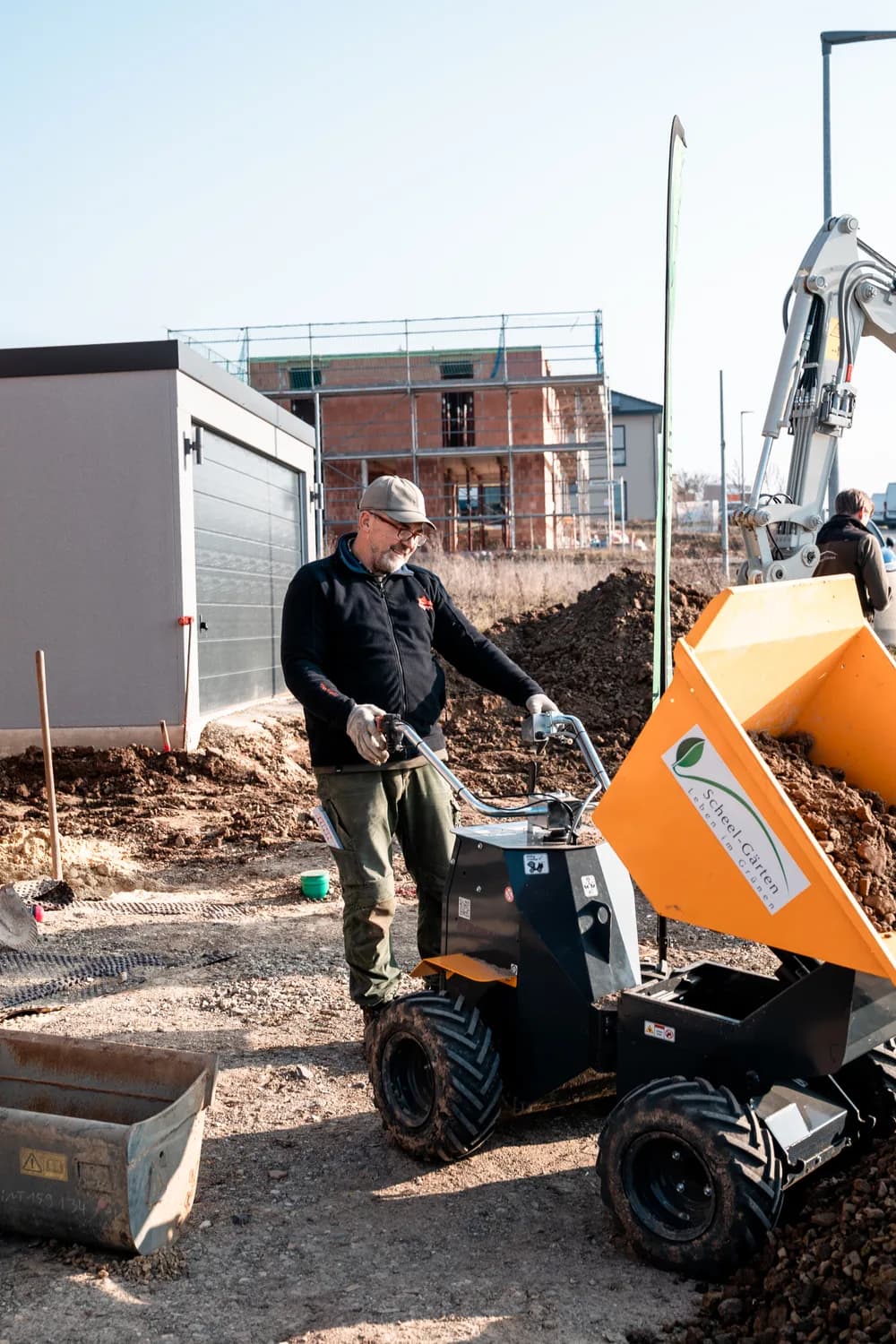 Facharbeiter steuert einen Mini-Dumper über die Baustelle
